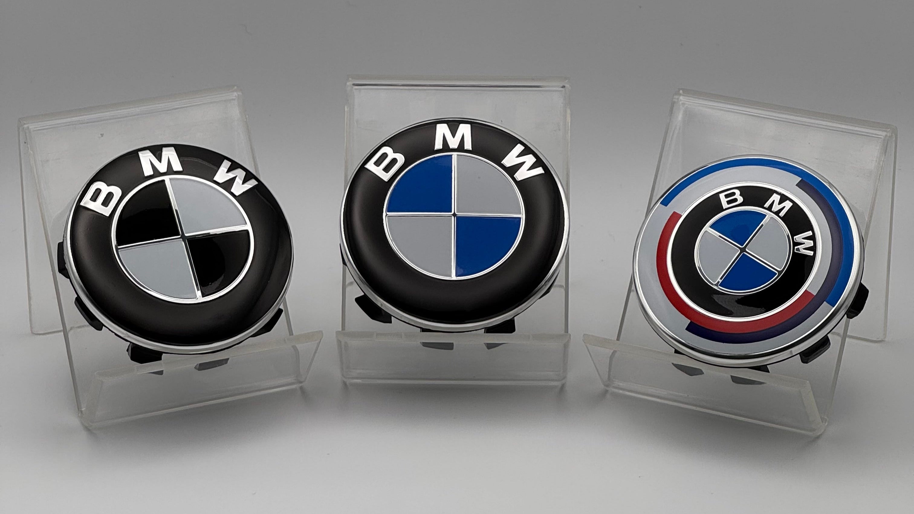 Three BMW logo car caps in clear display cases with a CentrecapsUK box above.